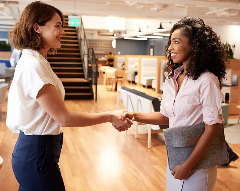 Two women shaking hands in office space for Abroad Study Consultancy Kerala